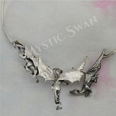 "Three magnificent dragons take flight in this stunning piece of sterling silver fantasy jewelry. The concept of the dragon necklace features three dimensional sculptures and an unique front clasp subtly incorporated into the design of the neckpiece; the result is a dragon trio statement necklace that seem to float around the wearer's neck, an artisan's creation that is sure to draw the eye of all who see it. Each of the dragons has a unique personality; the central dragon is the leader of the g Silver Dragon Design Jewelry For Fantasy Events, Silver Fantasy Jewelry With Dragon Design, Fantasy Silver Jewelry With Dragon Design, Silver Fantasy Necklace With Hand Cast, Fantasy Style Silver Jewelry With Unique Design, Hand Cast Fantasy Sterling Silver Jewelry, Fantasy Dragon Design Necklace, Oxidized Silver Fantasy Jewelry, Silver Oxidized Fantasy Jewelry