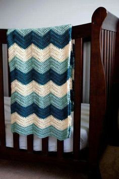 a crocheted blanket draped over a baby's crib