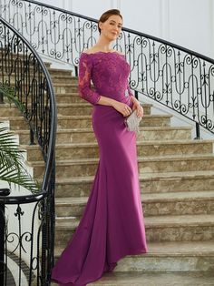 a woman in a long purple dress standing on stairs with her hand on her hip