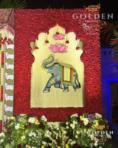 an elephant is painted on the side of a building with flowers in front of it