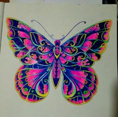 a drawing of a colorful butterfly sitting on top of a piece of paper with colored ink