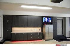 a kitchen with cabinets and a television on the wall