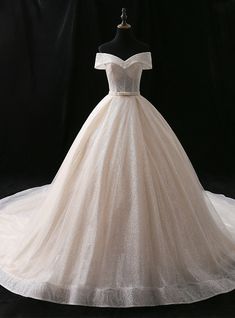 a white ball gown on a mannequin headdress in front of a black background