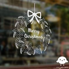 a christmas ornament hanging from the side of a glass window with a bow on it