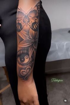 a woman with a black and grey tattoo on her arm