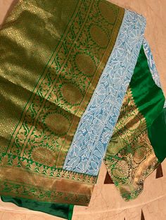 Neo-Ethnic Fusion at its best! Step into elegance with this Fusion Saree, featuring a stunning Blue Chikankari Hand-embroidered body paired with luxurious Green Banarasi Appliqued Borders and Pallu. The serene blue base provides a captivating backdrop, showcasing the intricate Chikankari hand embroidery that exudes timeless beauty and refined craftsmanship. The saree is adorned with rich green Banarasi silk borders and pallu, which are intricately appliqued with traditional motifs. The vibrant g Luxury Green Banarasi Silk Saree, Luxury Green Saree With Embroidered Border, Luxury Turquoise Dupatta With Zari Weaving, Luxury Silk Saree With Embroidered Border, Luxury Banarasi Silk With Chikankari Embroidery, Fusion Saree, Embroidered Saree, Traditional Motifs, Rich Green