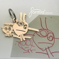 a close up of a key chain on a piece of paper with a drawing in the background