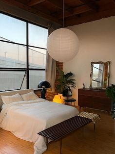 a bedroom with large windows and wooden floors