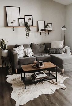 a living room with gray couches and pictures on the wall above them in black frames