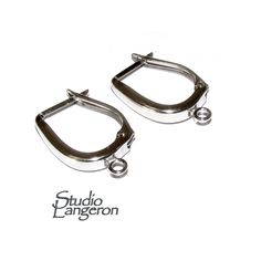 two pairs of silver metal hoop earrings on a white background with the words studio langeron