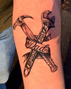 a tattoo on the arm of a man with two crossed wrenches