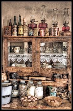 an old wooden cabinet filled with jars and other items