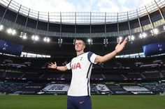 a man standing on top of a soccer field holding his hands out in the air