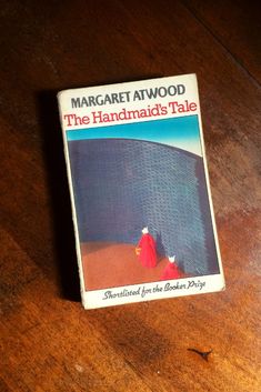 the handmade's tale by margartt atwood on a wooden table