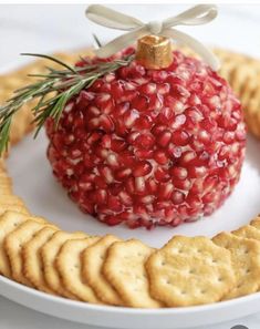 a pomegranate ornament on a plate with crackers around it