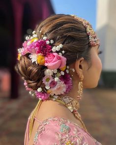 a woman with flowers in her hair is wearing a pink dress and headpieces