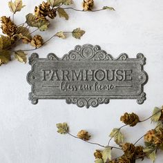 a metal sign that says farmhouse has all the love on it and is surrounded by dried leaves