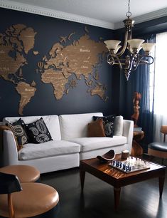 a living room filled with furniture and a world map on the wall above it's coffee table