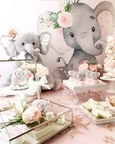 an elephant themed baby shower with pink and white flowers on the head, table cloth