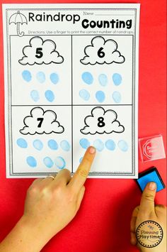 a hand is pointing at the numbers that are on top of a counting game for kids