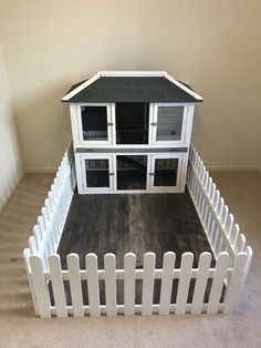 a dog house made out of white picket fence