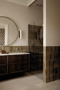 a bathroom with a sink, mirror and bathtub in the corner next to a walk - in shower