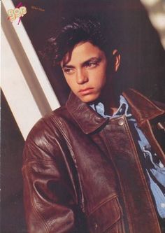 a young man wearing a brown leather jacket