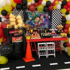 a birthday party with mickey mouse balloons and candy buffet table set up for an event