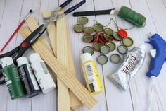 craft supplies laid out on a white wooden table with glue, scissors and other items