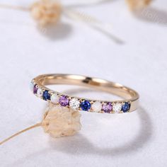 an image of two wedding rings with different colored stones on the side and one is yellow gold