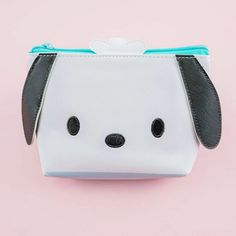 a small white and black dog purse on a pink background