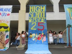 several girls standing in front of a high school musical banner