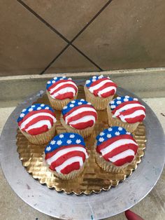 cupcakes decorated with red, white and blue icing on a silver platter