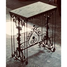 an iron table with marble top on the floor