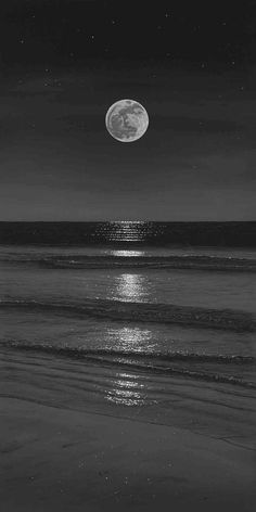 the moon is shining over the ocean on a dark night with stars in the sky