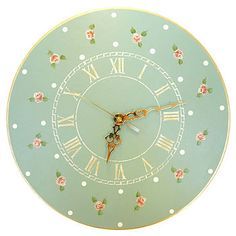 a blue clock with white polka dots and pink roses on the face is shown against a white background