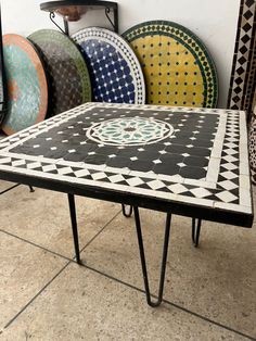 a table that is sitting in front of some plates on the floor with different designs