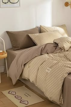 a bed sitting in a bedroom next to a wooden table with a lamp on top of it