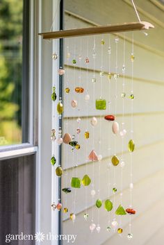 a wind chime hanging from the side of a house in front of a window