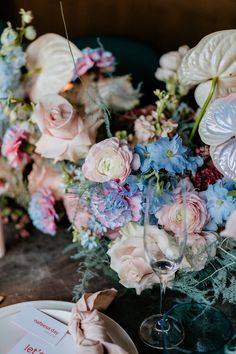 the table is set with pink and blue flowers