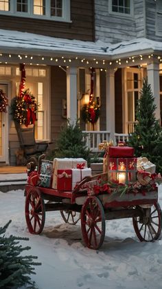 a horse drawn carriage with presents on it in front of a house decorated for christmas