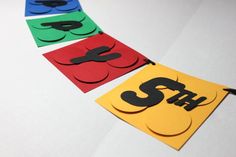 four different colored paper banners with the word sth on them, hanging from strings