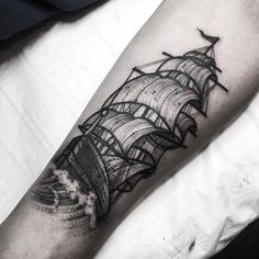 a black and white photo of a ship tattoo on the leg