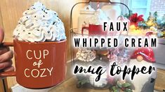 a cup of whipped cream is being held up by someone's hand with the words cup of cozy written on it