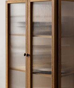 a tall wooden cabinet with glass doors