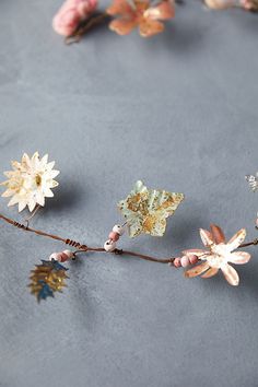 flowers and leaves are arranged on a gray surface