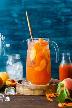 a pitcher filled with orange juice and sliced peaches