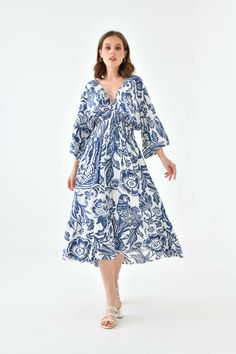 Say hello to our Oversized Flutter Sleeves Shirred Waist V Neck Midi Dress with Floral Print in Navy and White. With shirred waist an elegant mid length and flutter sleeves, this dress is perfect to wear at a wedding or a date night with that special someone. Match this dress with short heel sandals and a mini bag! SPECS: Material: Viscose Color: Navy Fit: Relaxed Size: Oversized *Suitable for UK size 8-16 Product Highlight: ● Oversized fit with details. ● Versatile design. ● Suitable for various occasions. ● Flattering fit. ● A versatile addition to your wardrobe. 💦CARE INSTRUCTIONS: ● Check the care label for instructions. ● Pre-treat stains before washing. ● Machine wash on a gentle cycle with cold water. ● Use a mild detergent suitable for delicate fabrics. ● Avoid bleach and fabric s Vacation V-neck Midi Dress With Gathered Sleeves, Chic Billowy Floral Print Midi Dress, Vacation Dress With Gathered Long Sleeves, Long Sleeve Dress With Gathered Sleeves For Vacation, Vacation Dresses With Gathered Long Sleeves, Brunch Midi Dress With Floral Print, Blue Vacation Dresses With Gathered Sleeves, Blue Dresses With Gathered Sleeves For Vacation, Blue Beach Dress With Gathered Sleeves