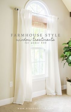 a window with white curtains and a potted plant