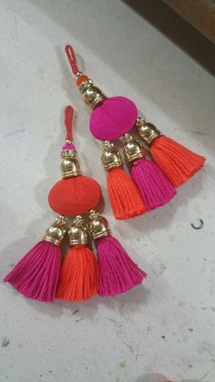 two pairs of earrings with tassels on them